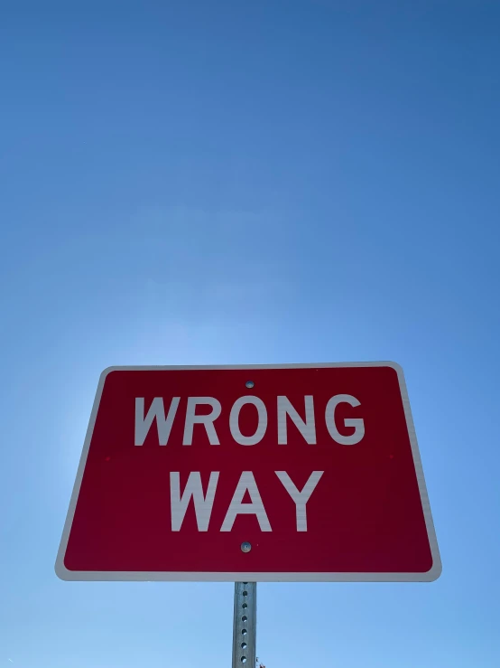 this is an wrong way sign under a blue sky