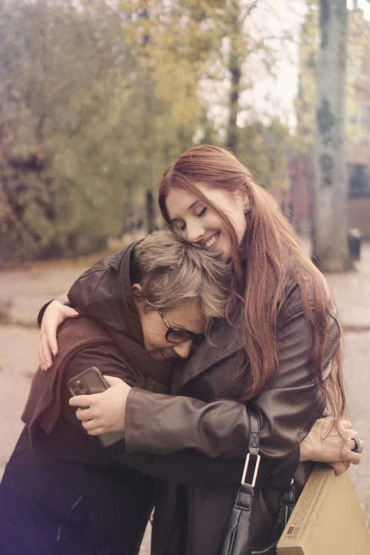 two people on the phone hugging outside