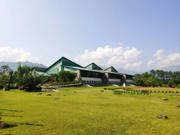 a big building with a green roof on a field