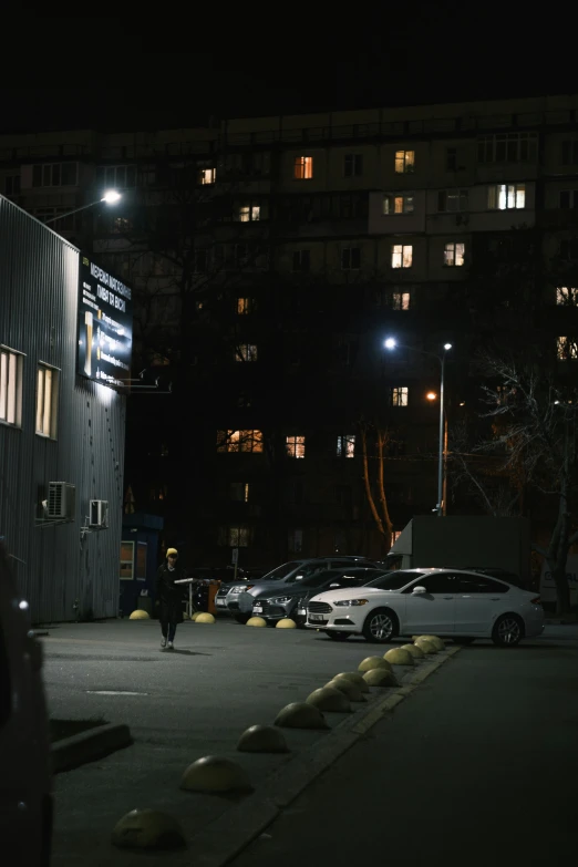 several cars parked in a parking lot at night