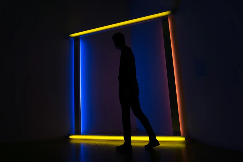 a man standing in front of a wall with fluorescent colors