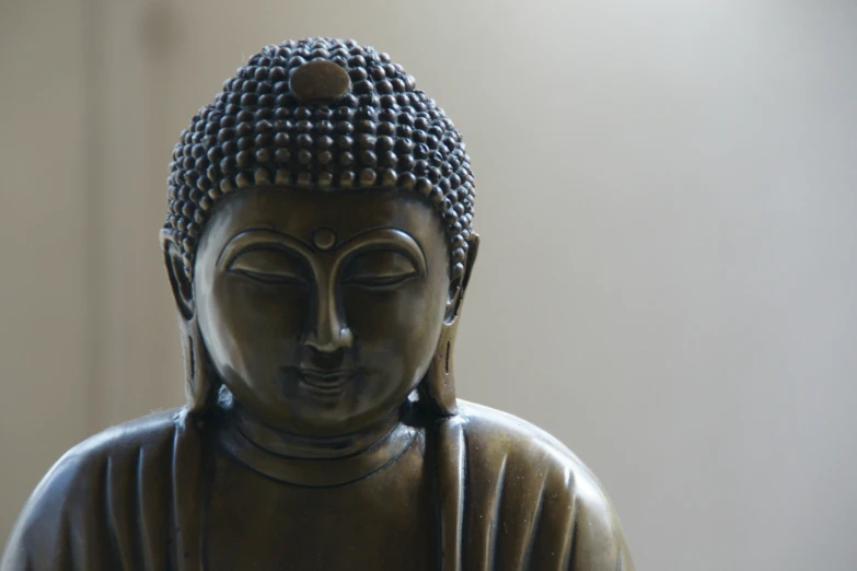 a statue of a seated buddha, head tilted on the other side
