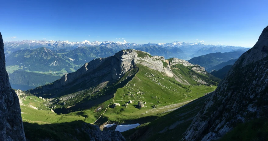 a mountain with lots of green grass and rocks on top