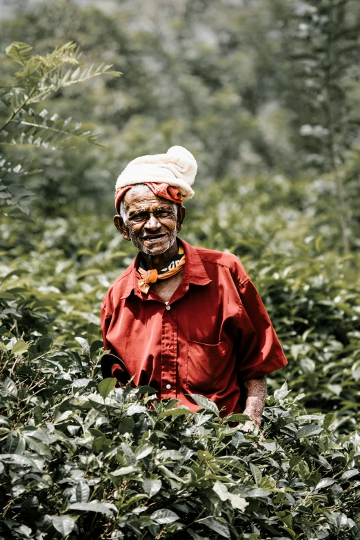 a man wearing a turban standing in a field of trees