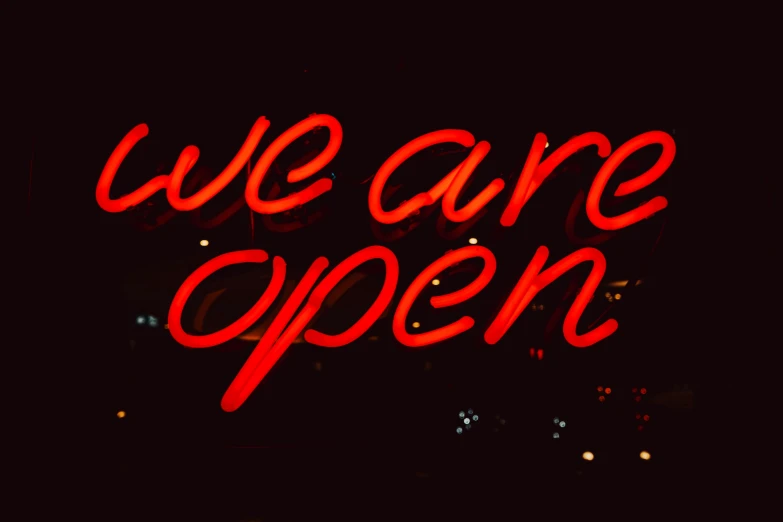 we are open neon sign displayed outside on a dark night