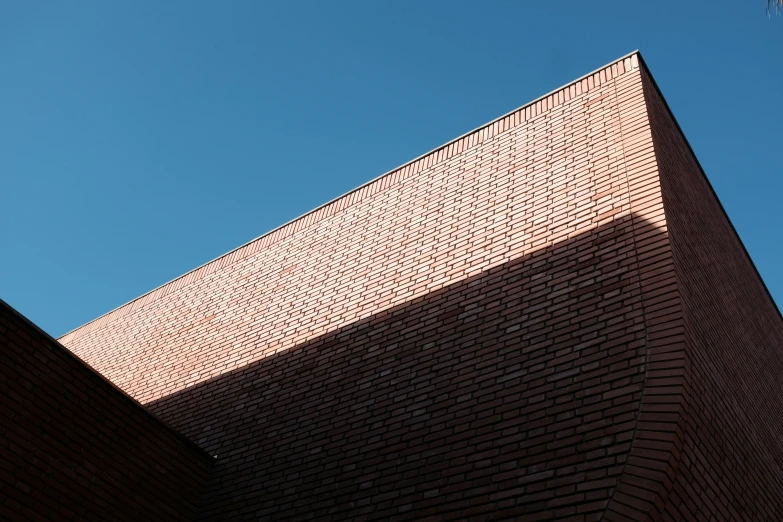 the corner of a brick wall against a blue sky