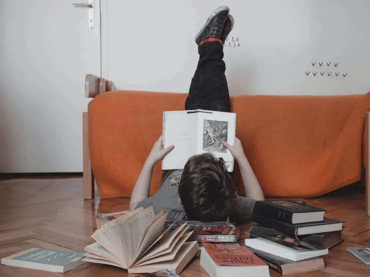 a person laying on the floor reading a book