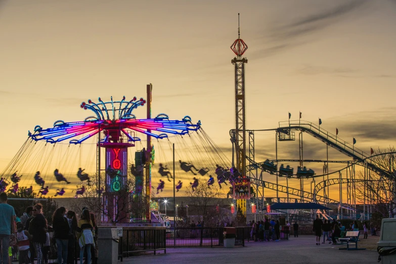 a carnival ride is lit up at dusk