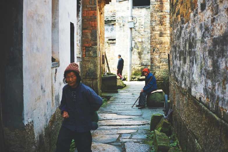 several children with hats are walking through alleyways