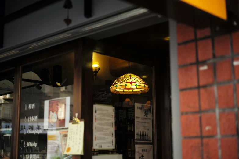 the light fixture hangs from a store front window