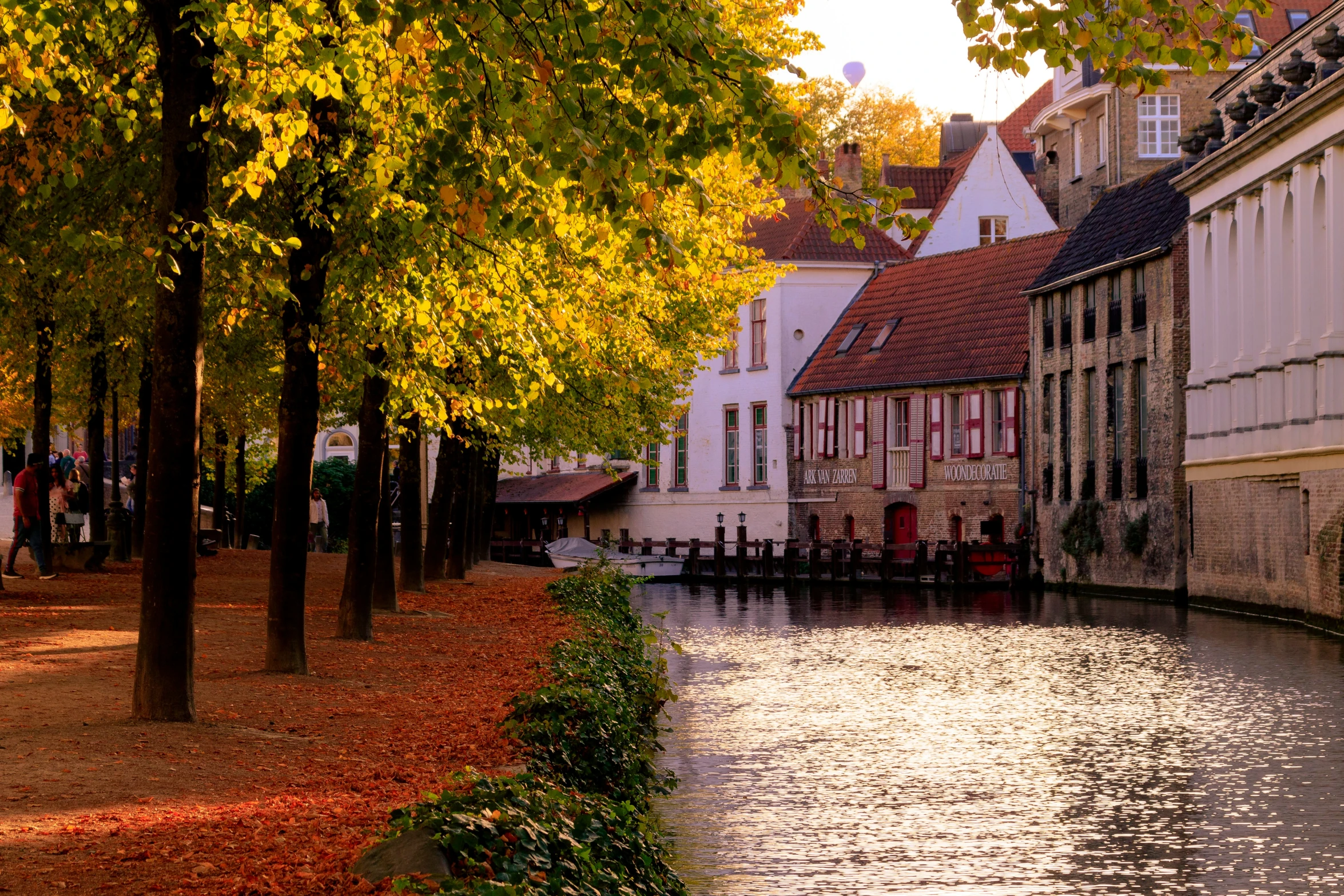 people sitting on benches at the edge of the river