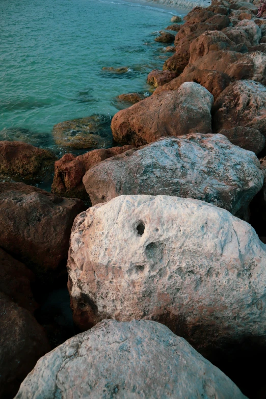 some rocks and water on the side of the beach