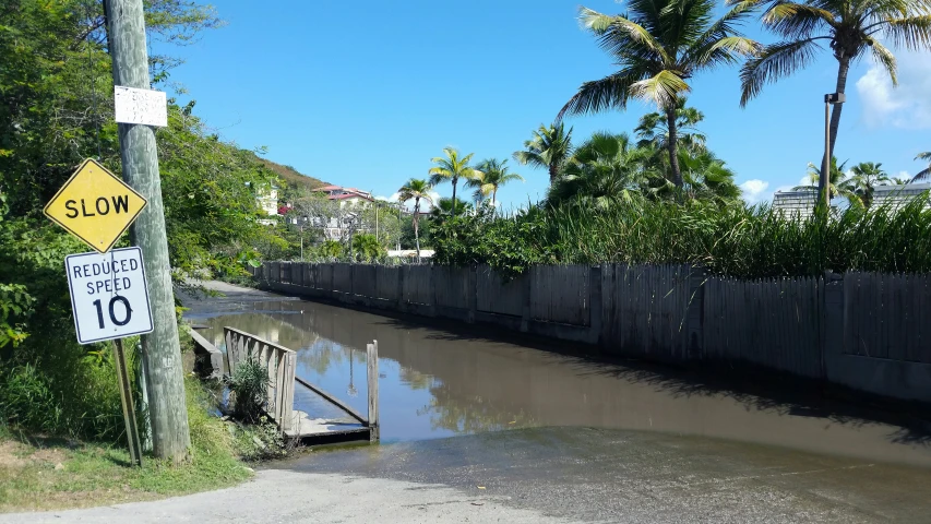 a street sign and a pole near water