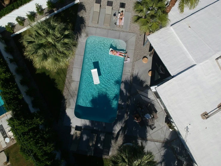 an aerial view of a pool, with one person laying on the water