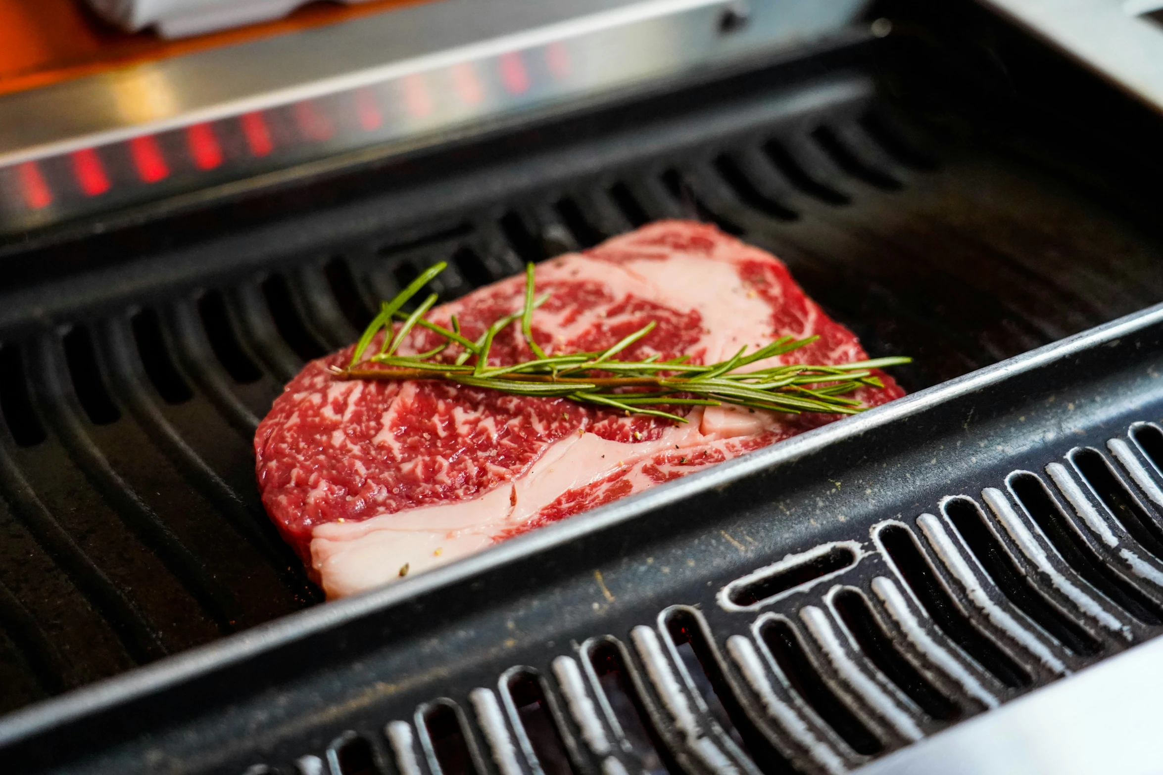 a piece of raw steak laying in a grill