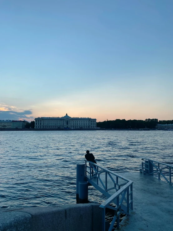 a man that is standing on a rail next to some water