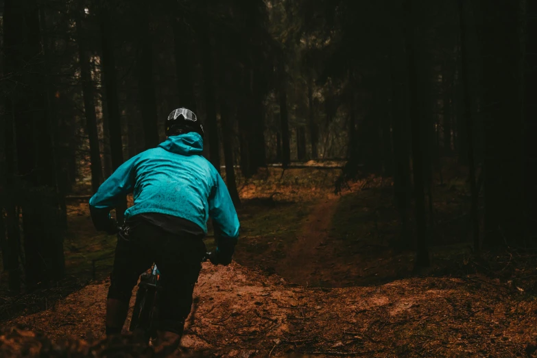 man wearing jacket and blue riding on dirt road