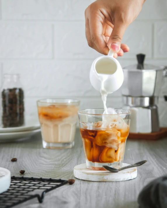 someone squeezing a cup of ice into a drink