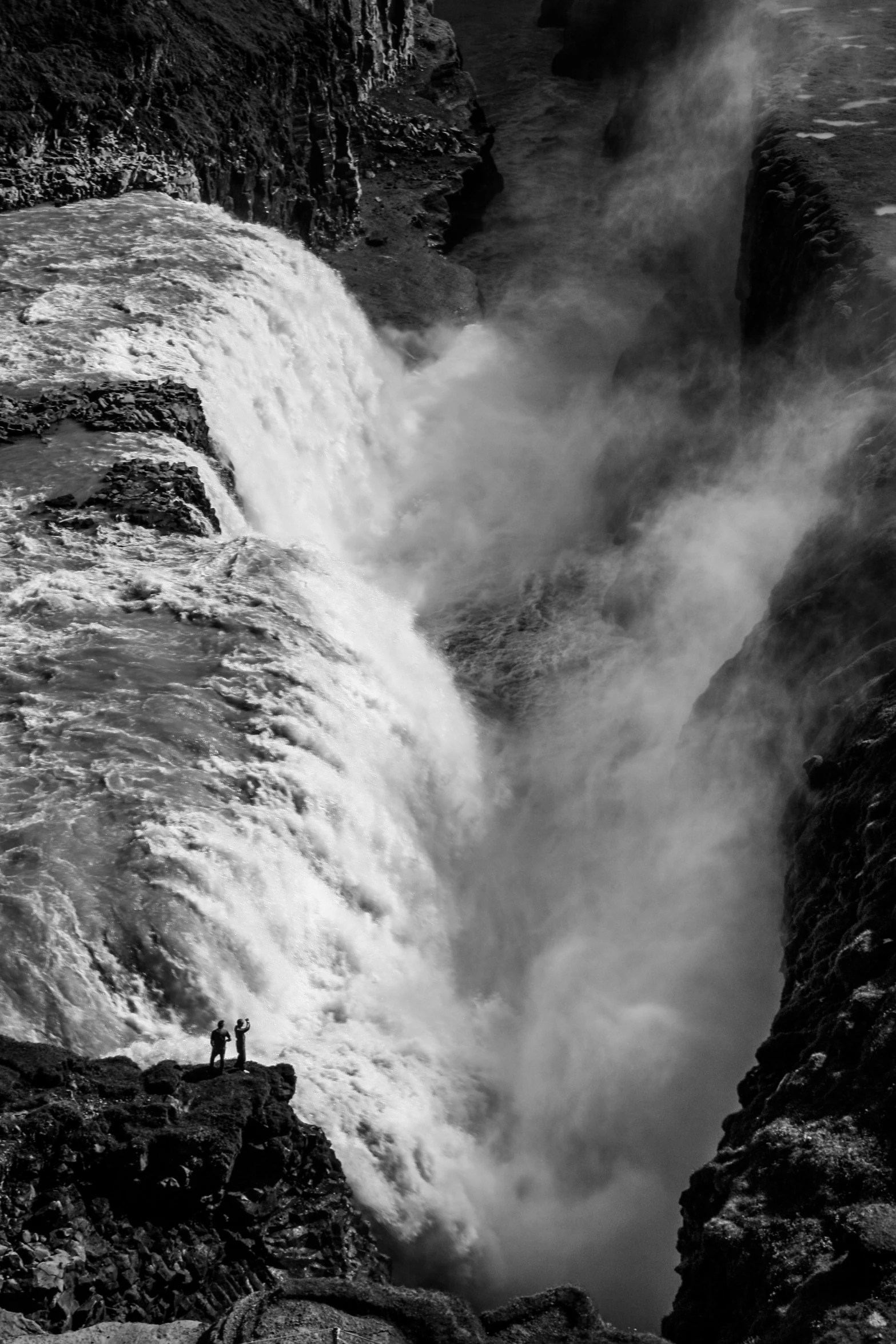 a man standing in the middle of a huge waterfall