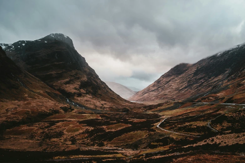 a winding road cuts through the rocky mountains