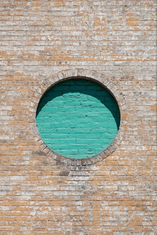 an unusual window on the side of a brick building