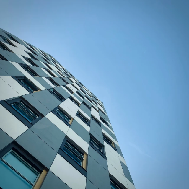 an upward view of the side of a building with glass windows