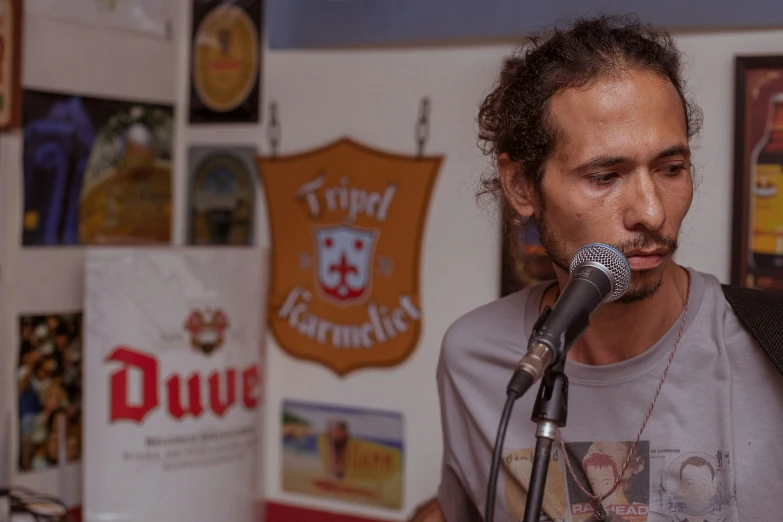 a man with long curly hair singing into a microphone