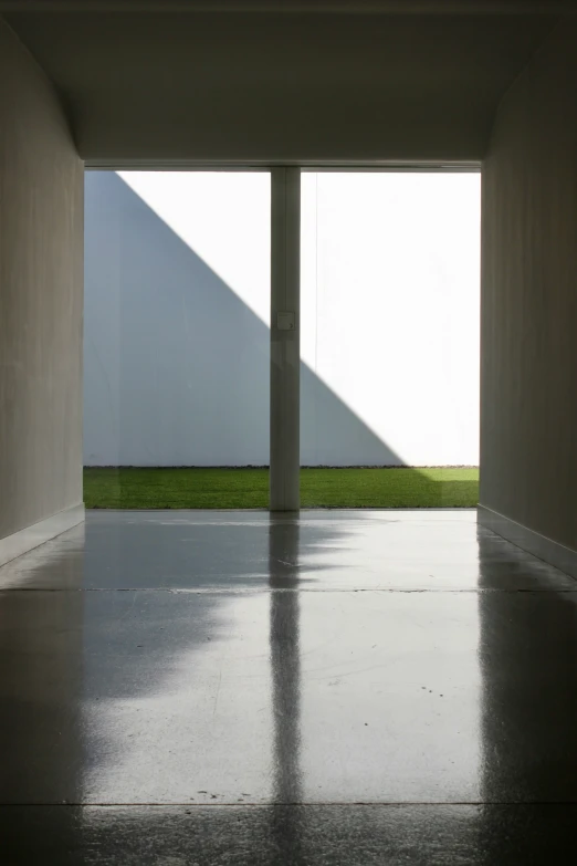 a white room with a green grassy area in the background