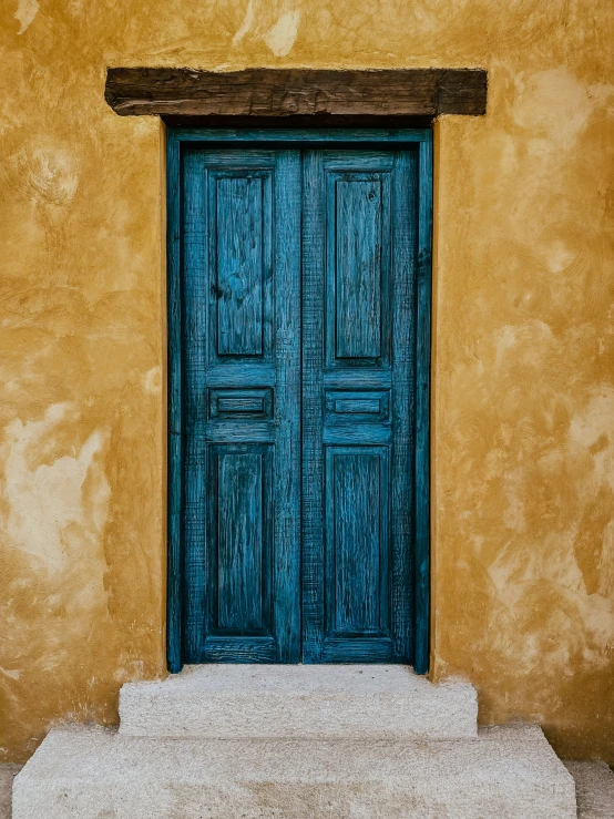 blue doors sitting in the side of an old building