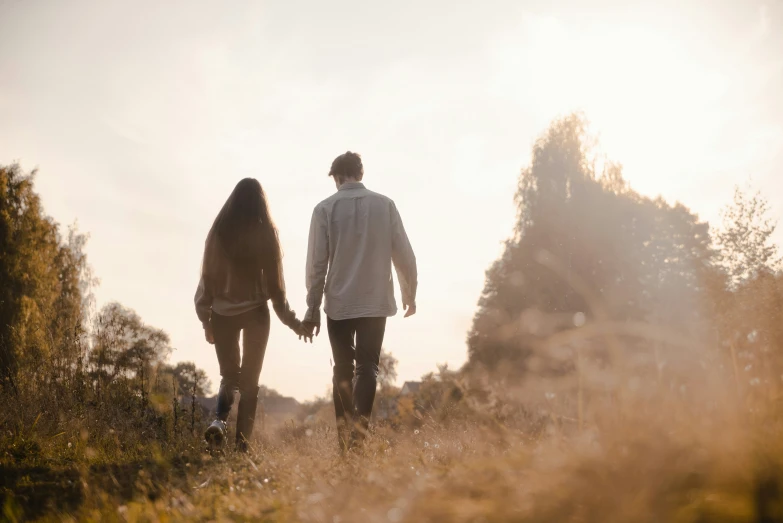 a couple of people walking down a field