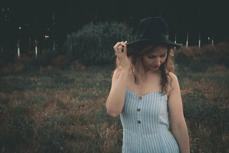 a woman in a field wearing a hat
