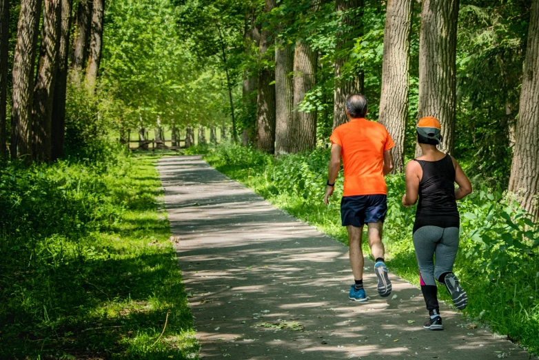 two people that are running down a path