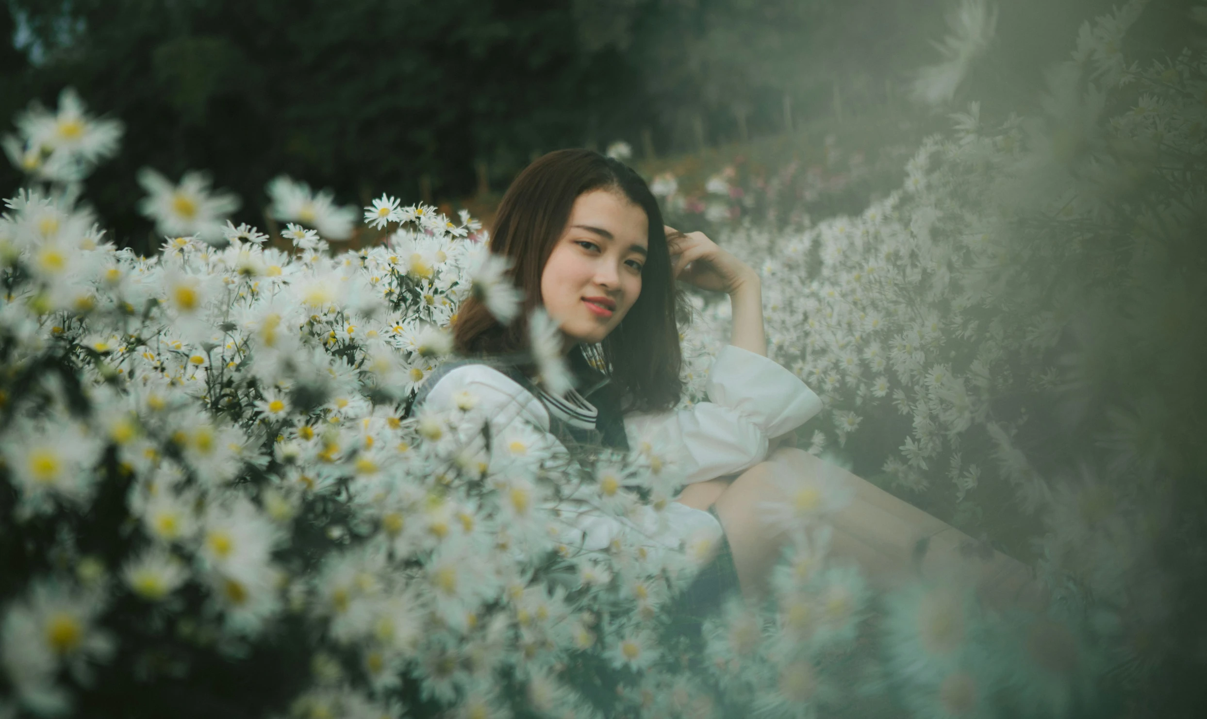 a woman in a flowery field looks away from the camera