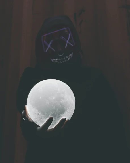 a person is holding a glowing ball in their hands
