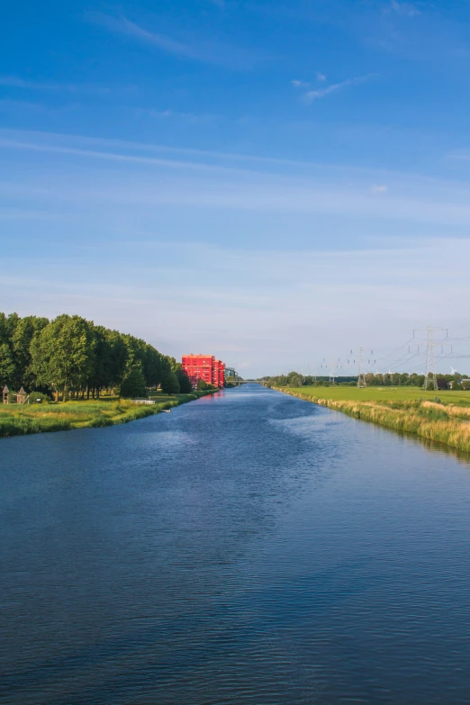 a small red train on tracks next to a river