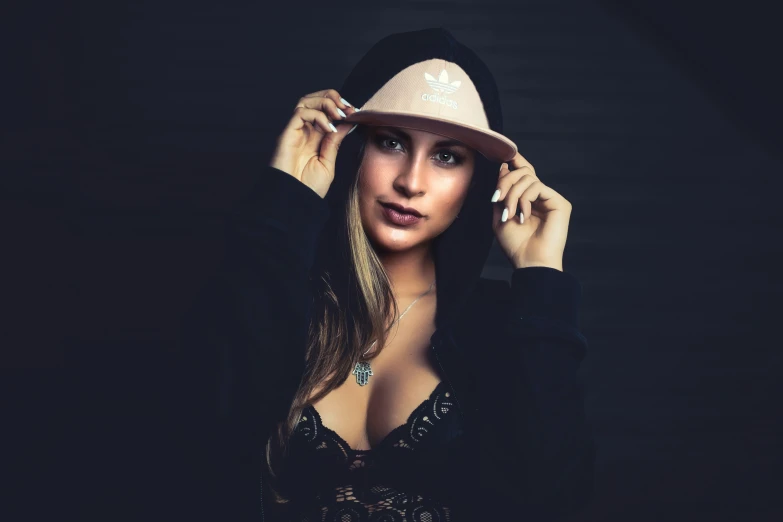 a young woman wearing a hat is standing in a dark room