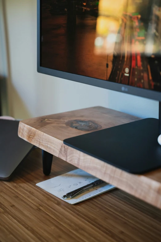 a laptop computer screen mounted on a wooden shelf