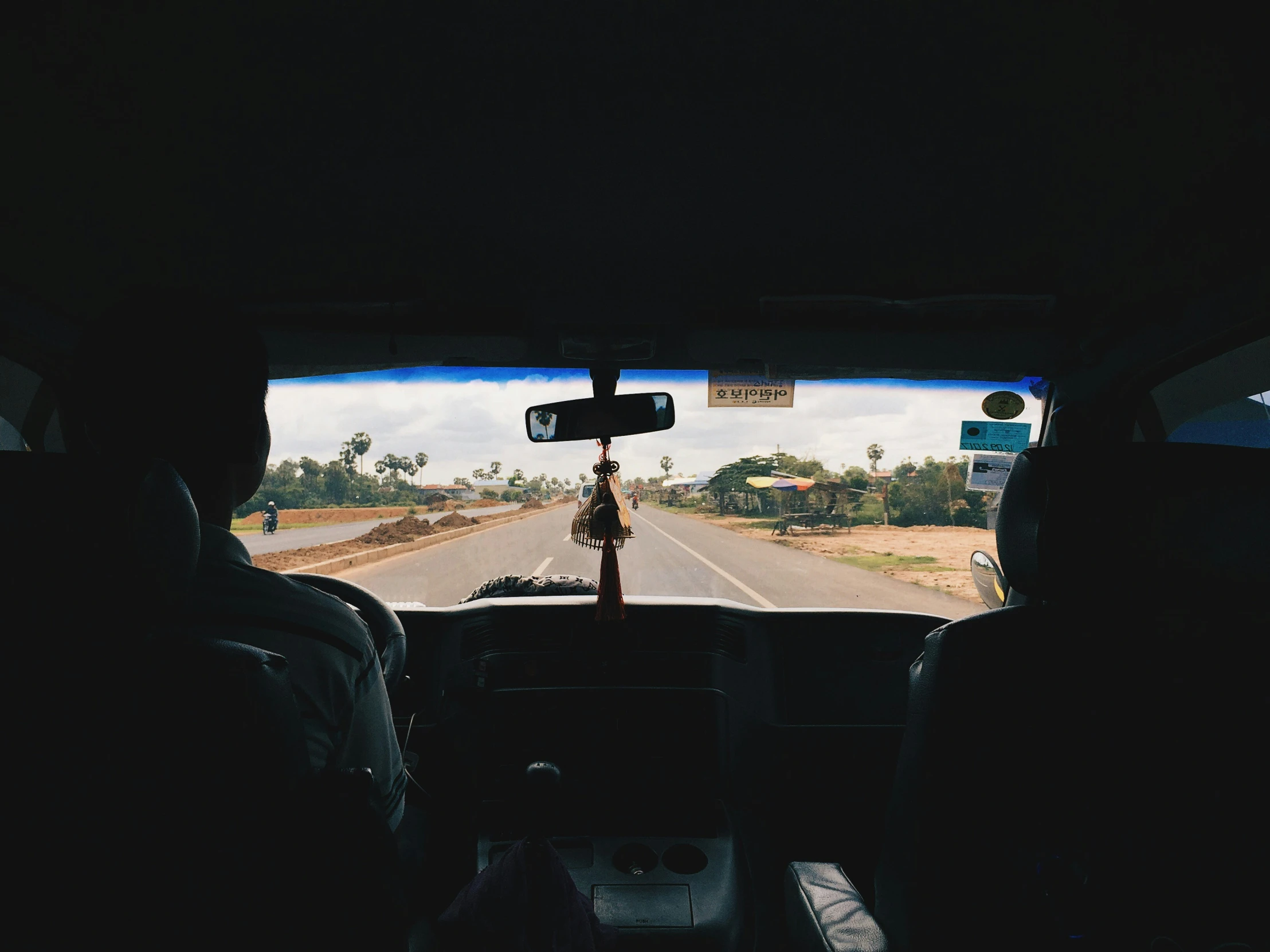 two people sitting in a car driving on a street