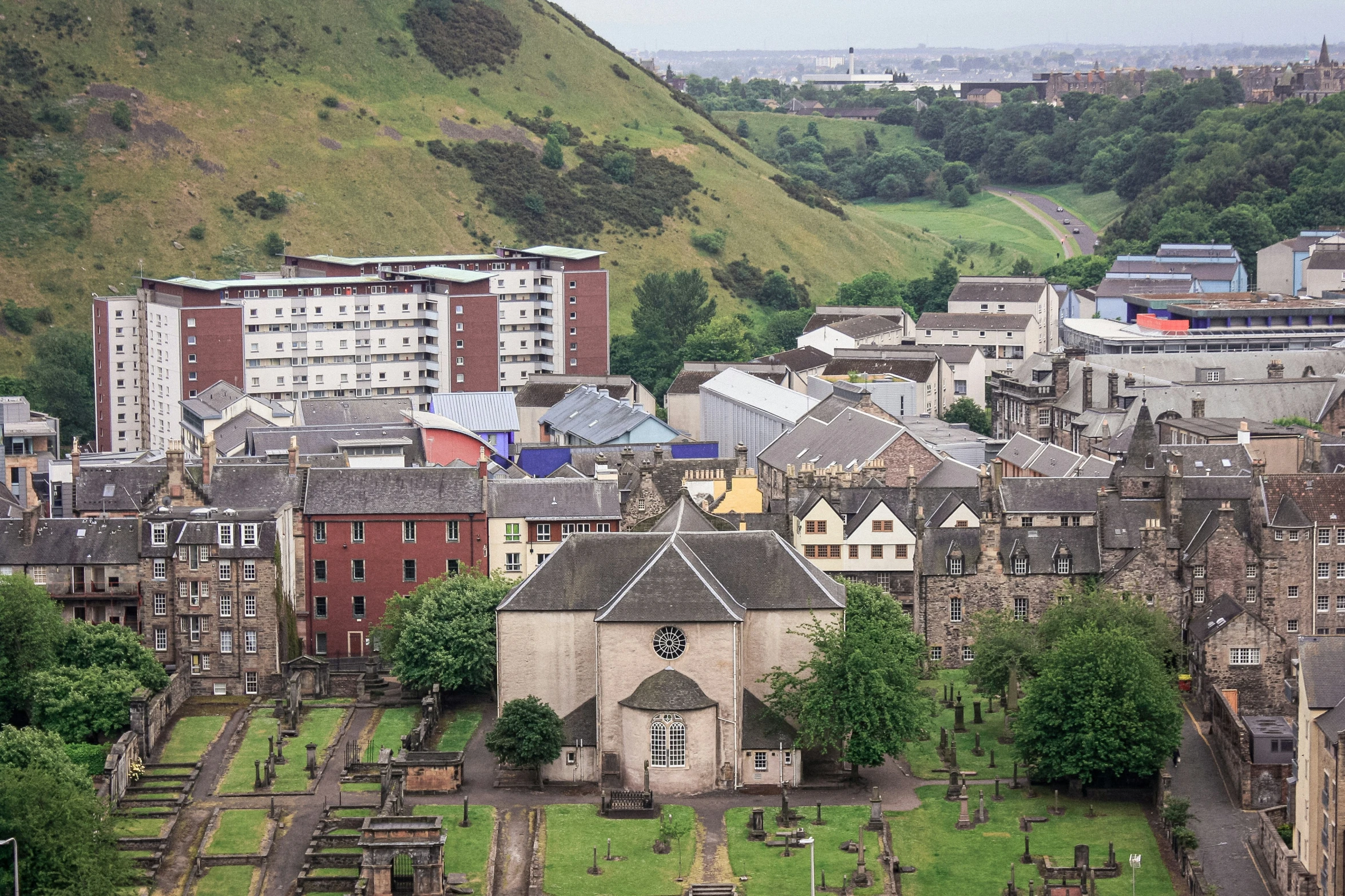 a church building sits among several different buildings on a city's hillside