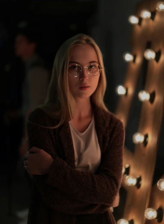 woman in front of multiple lights and leaning her arm on her chest