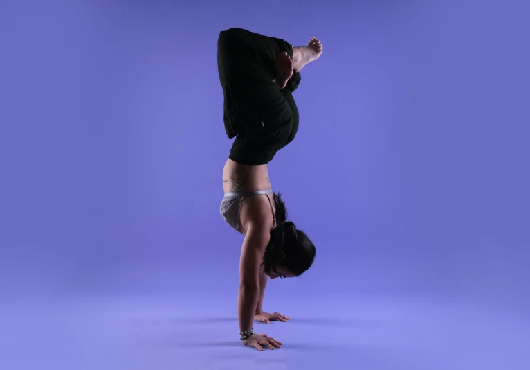 woman in a yoga pose against a purple background