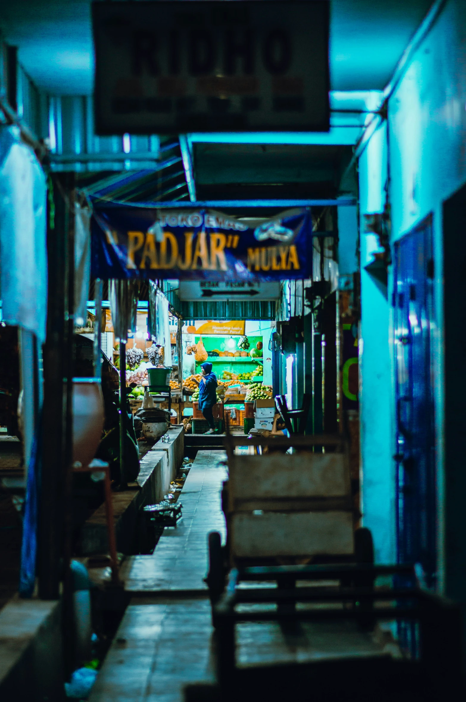 a very narrow walkway way with signs on the side of it