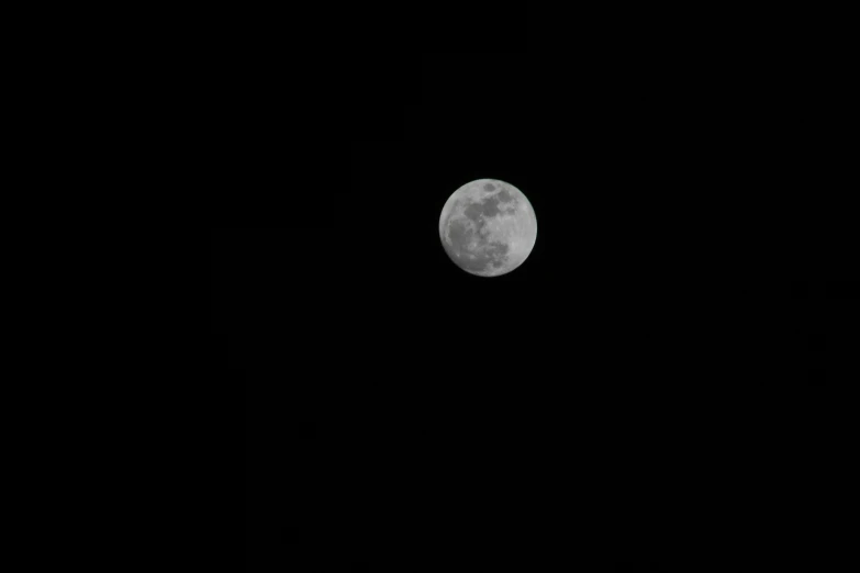 the moon is visible above some dark skies