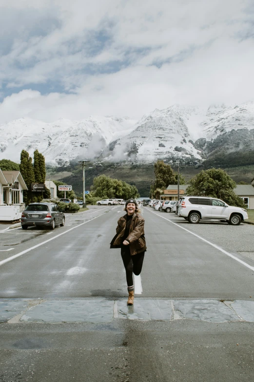 a woman crossing the street in front of a town