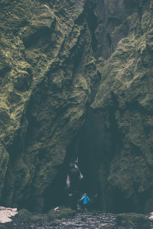 a man on surf board going through a cave