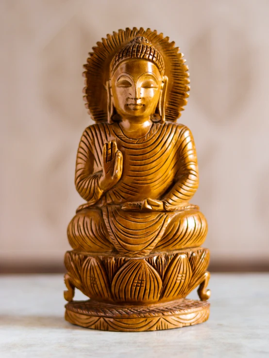 a golden buddha statue sitting on top of a white table