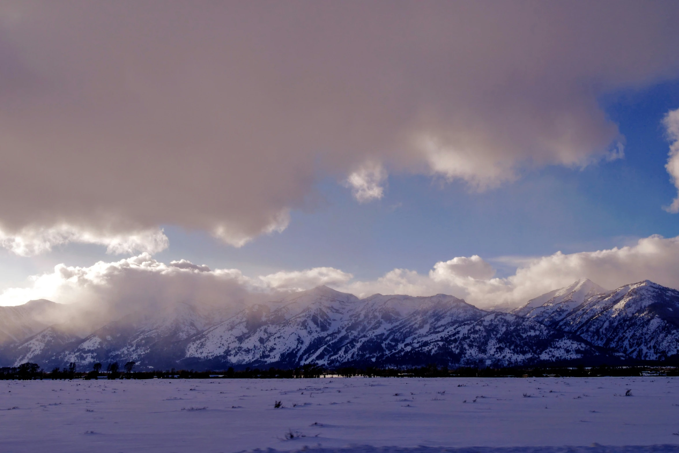 a cloudy day in the mountains with mountains in the background