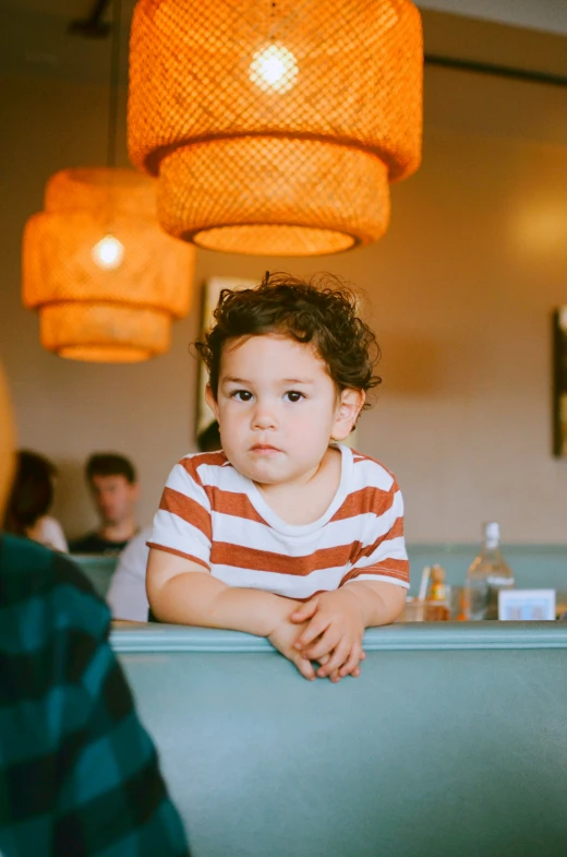 a young child sitting in the counter at a restaurant