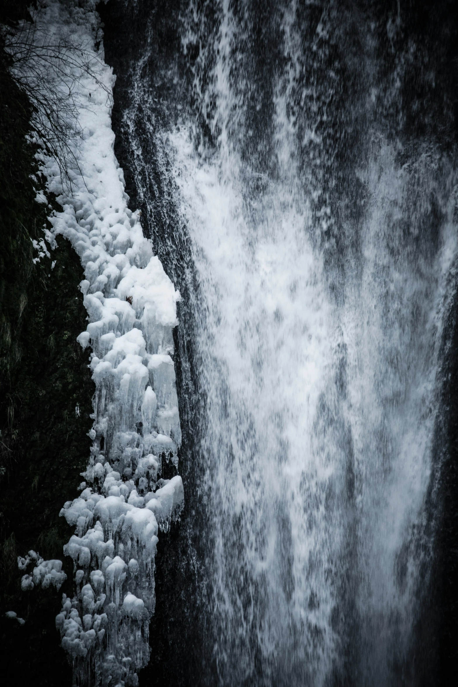 a waterfall flowing into the air with ice around it