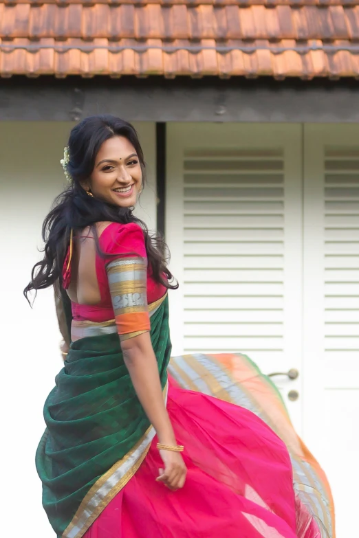 a woman in a colorful sari is walking outside